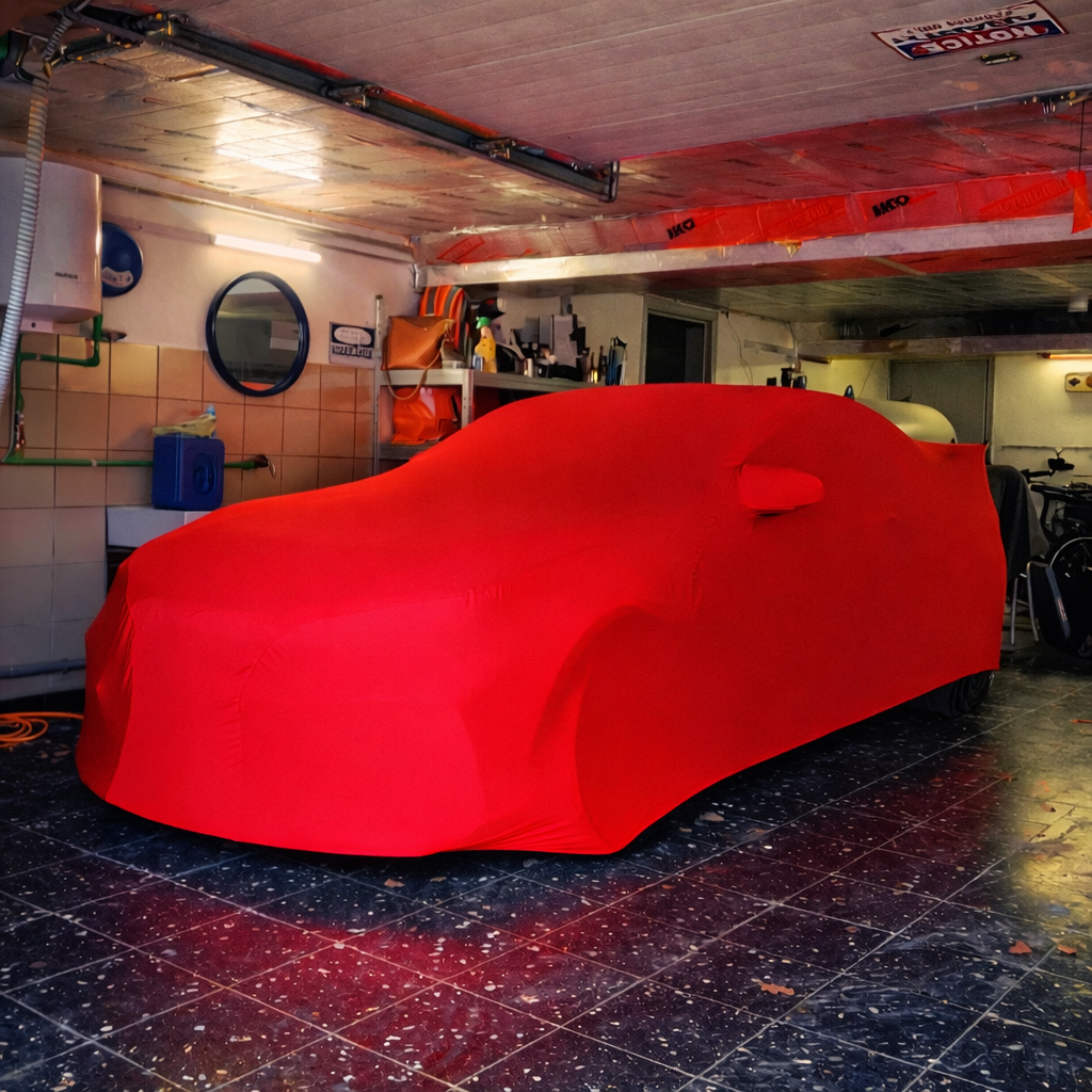 voiture bmw protégée par housse rouge dans un garage